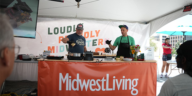 Two men behind a table cooking